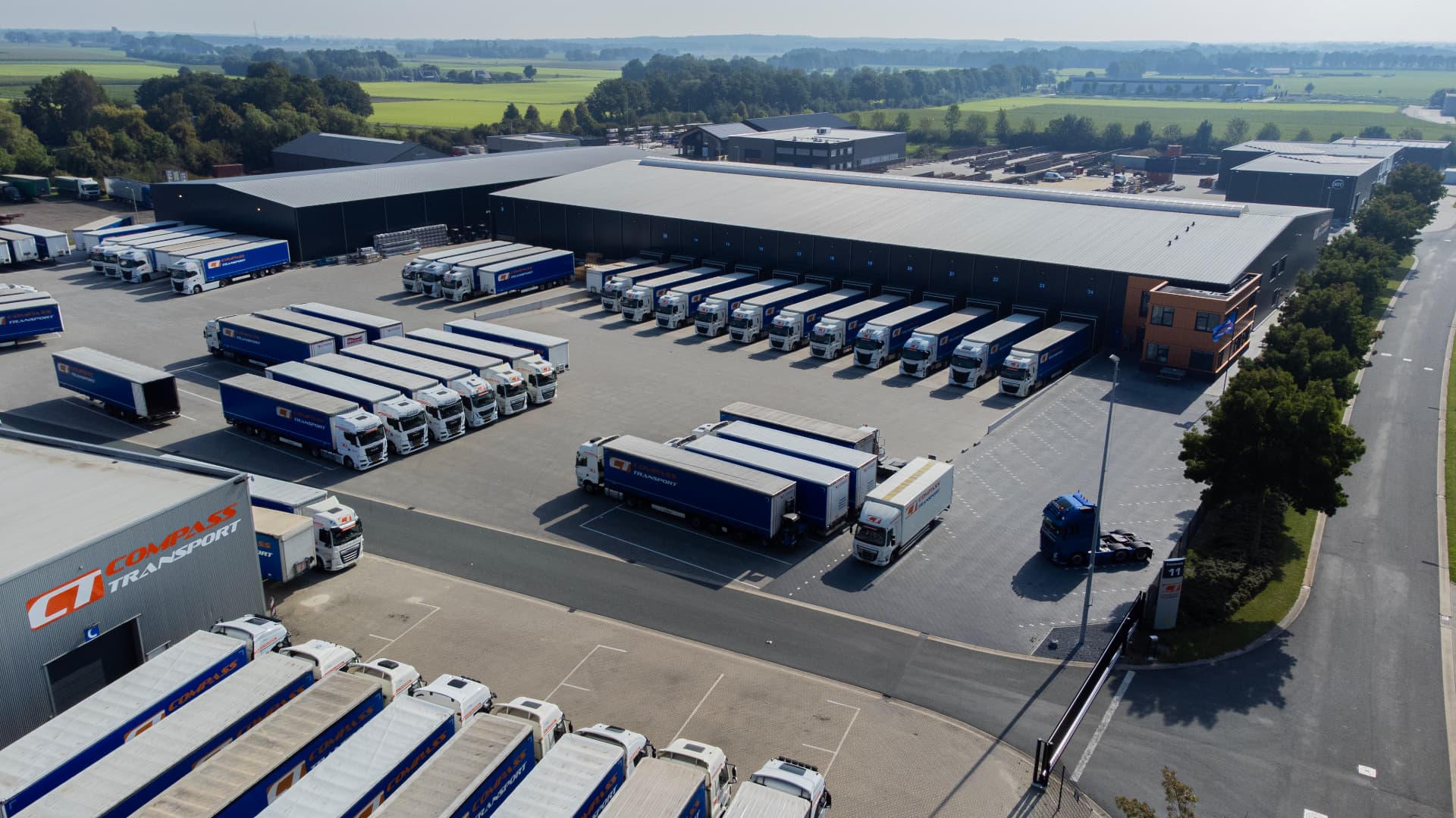 Luchtfoto van de locatie aan de Zwedenweg met vrachtwagens aan de docks
